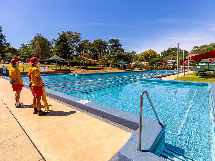 Lifeguards standing beside outdoor pool