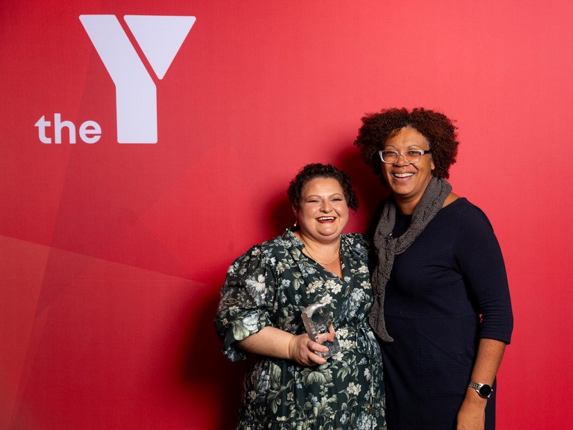 Attendees at Victorian Mother of the Y standing in front of the Y logo