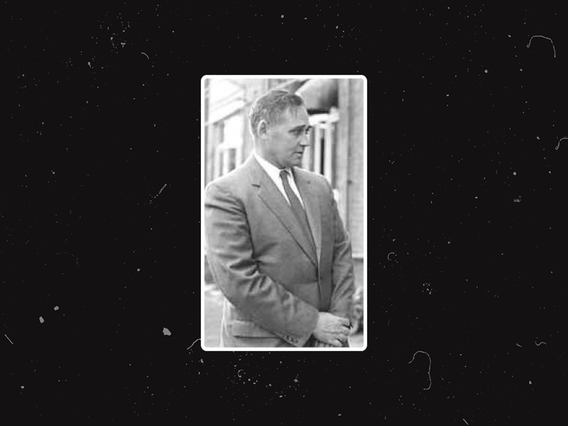 Image of Dr Percival Bazeley standing outside a factory in the 1950's