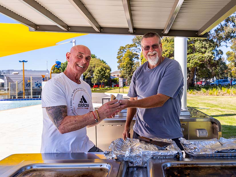 Two men outdoors having a barbeque